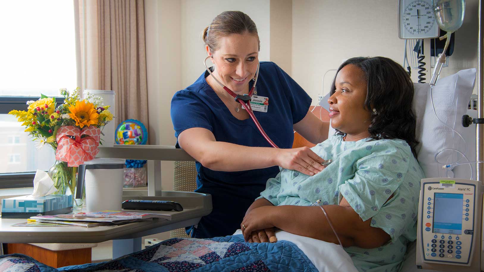 A nurse listens to a patient's heartbeat. 