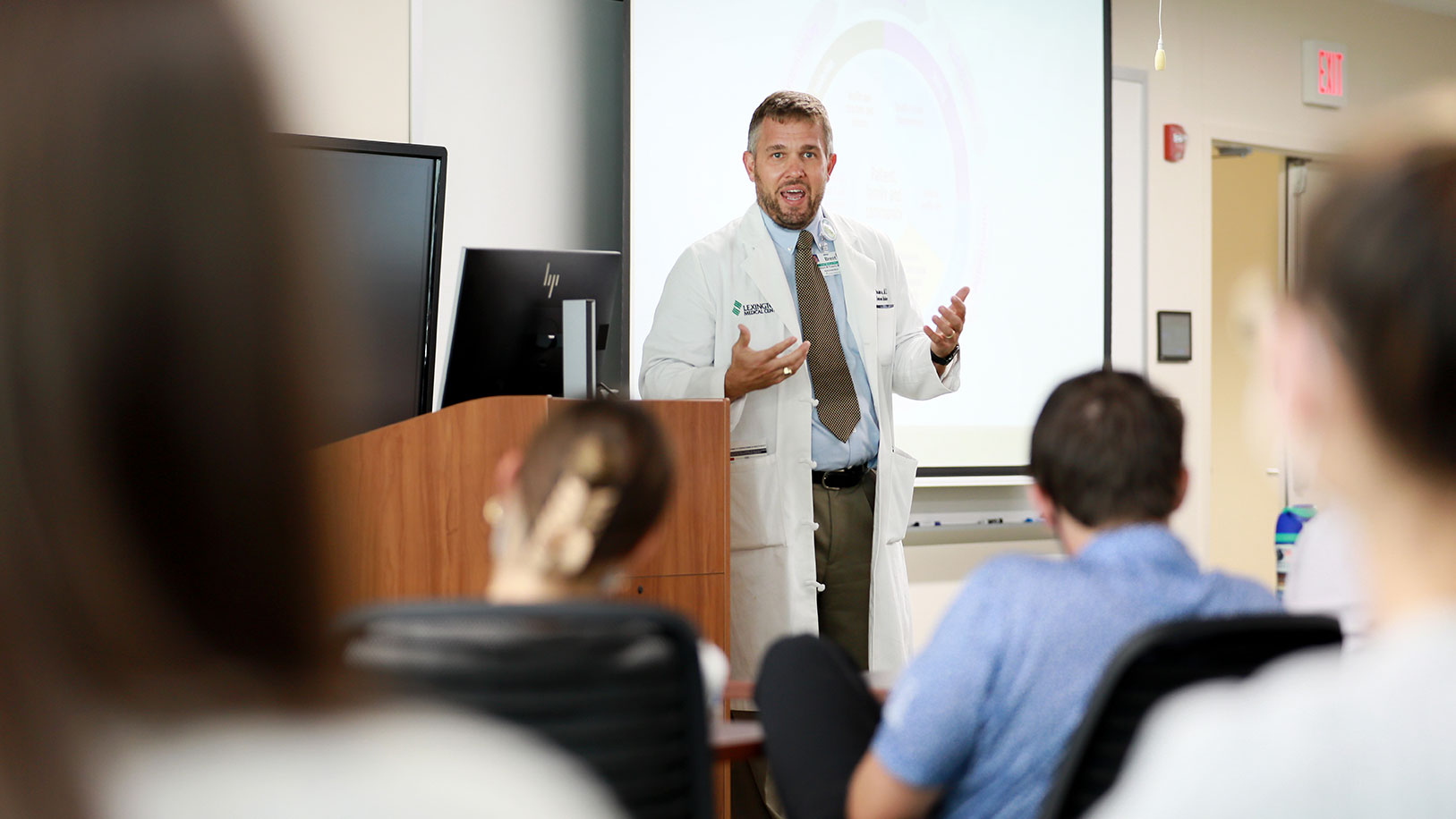 Residents work on an activity in a classroom while a faculty member supervises. 