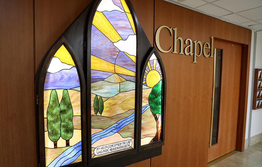 The chapel at the hospital. There is a stained glass of a meadow and shining sun that decorates the outside of the chapel.