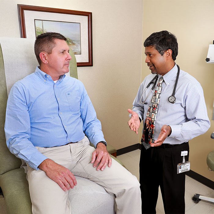 Keller Kissam in a doctors' office, speaking with a physician. 