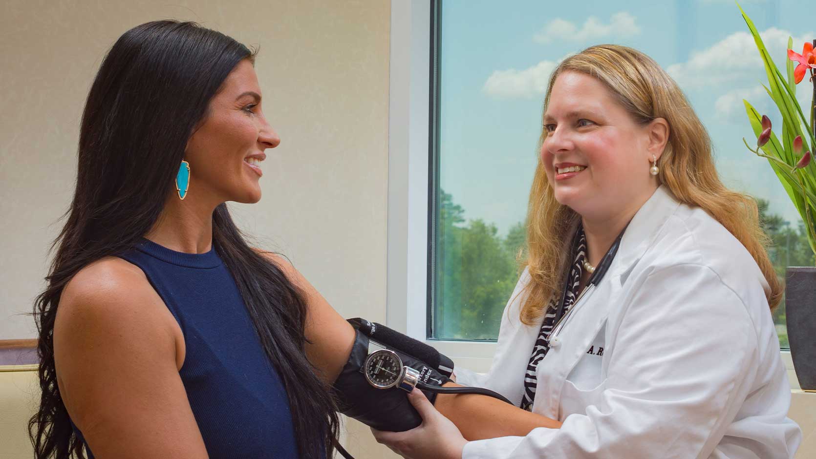 Gynecologist checking a patient's blood pressure.